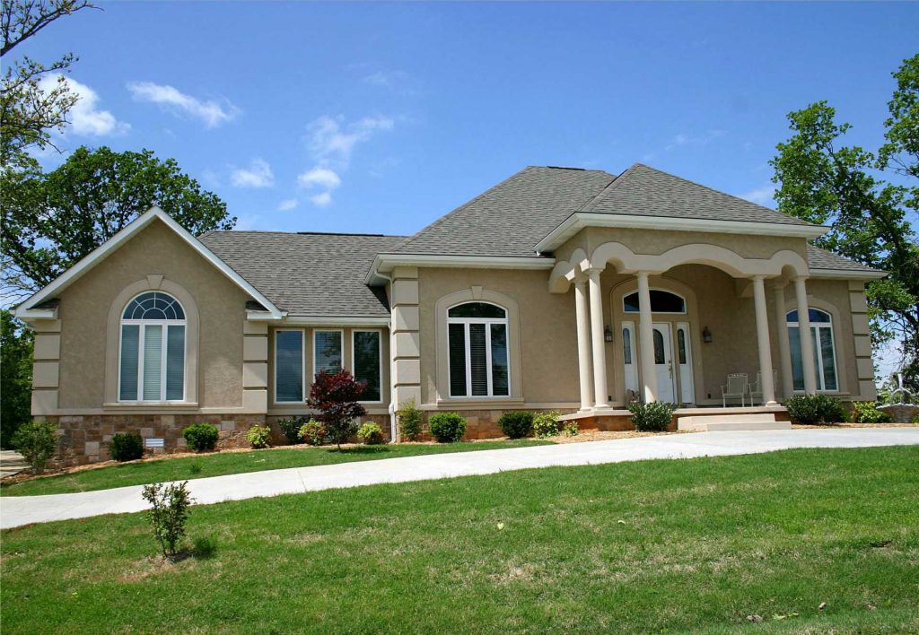 roofing company tan stucco house with new asphalt roof