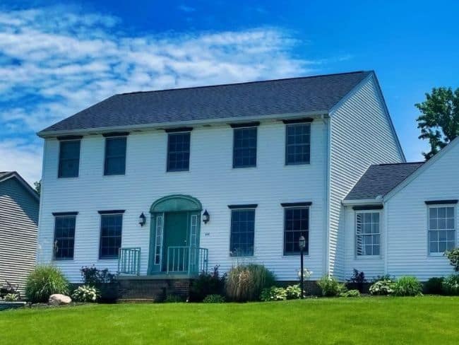 two story home with white vinyl siding and gray asphalt shingles roof installed by local roofing contractors