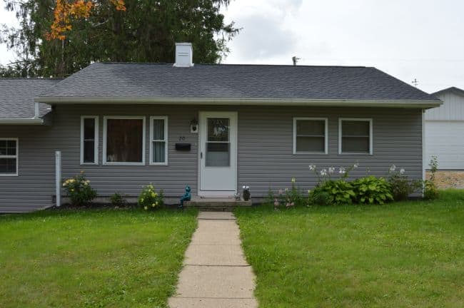 roofers near me home with shingle roof and gray vinyl siding