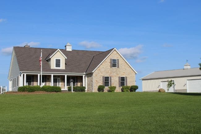 roofing companies Columbus Ohio home on hill with new roof installation and vinyl siding