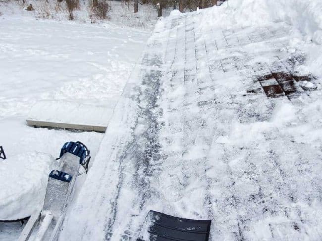 roofers ladder to remove snow and ice because of ice dams