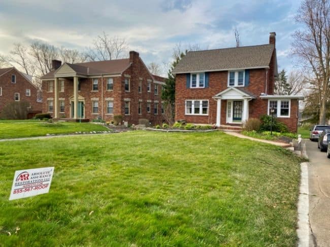 photo from street of brick home with roof installation by roofers in Lexington Ohio