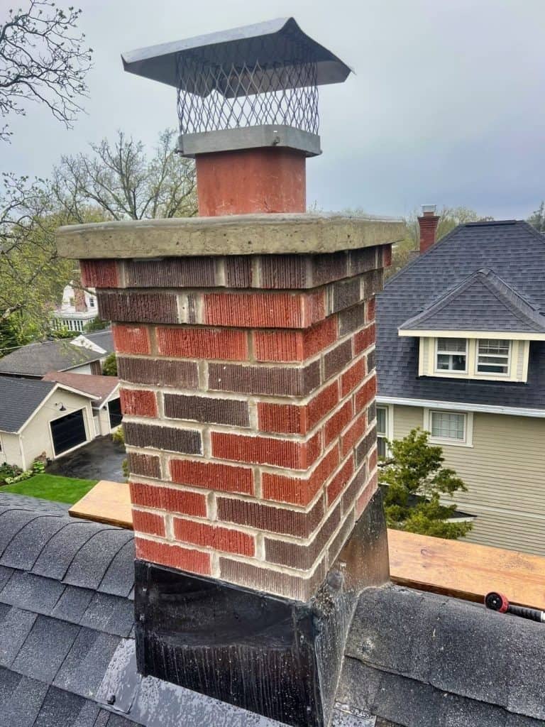 closeup view of chimney rebuild with new flashing at bottom and installed on new roof