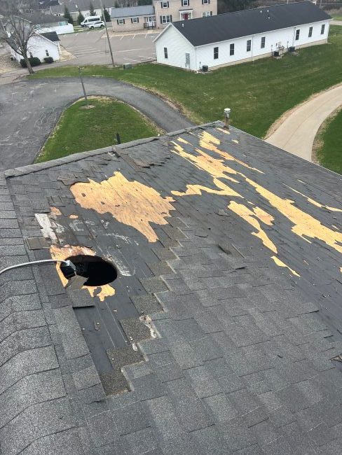 image of the edge of a damaged roof with missing shingles
